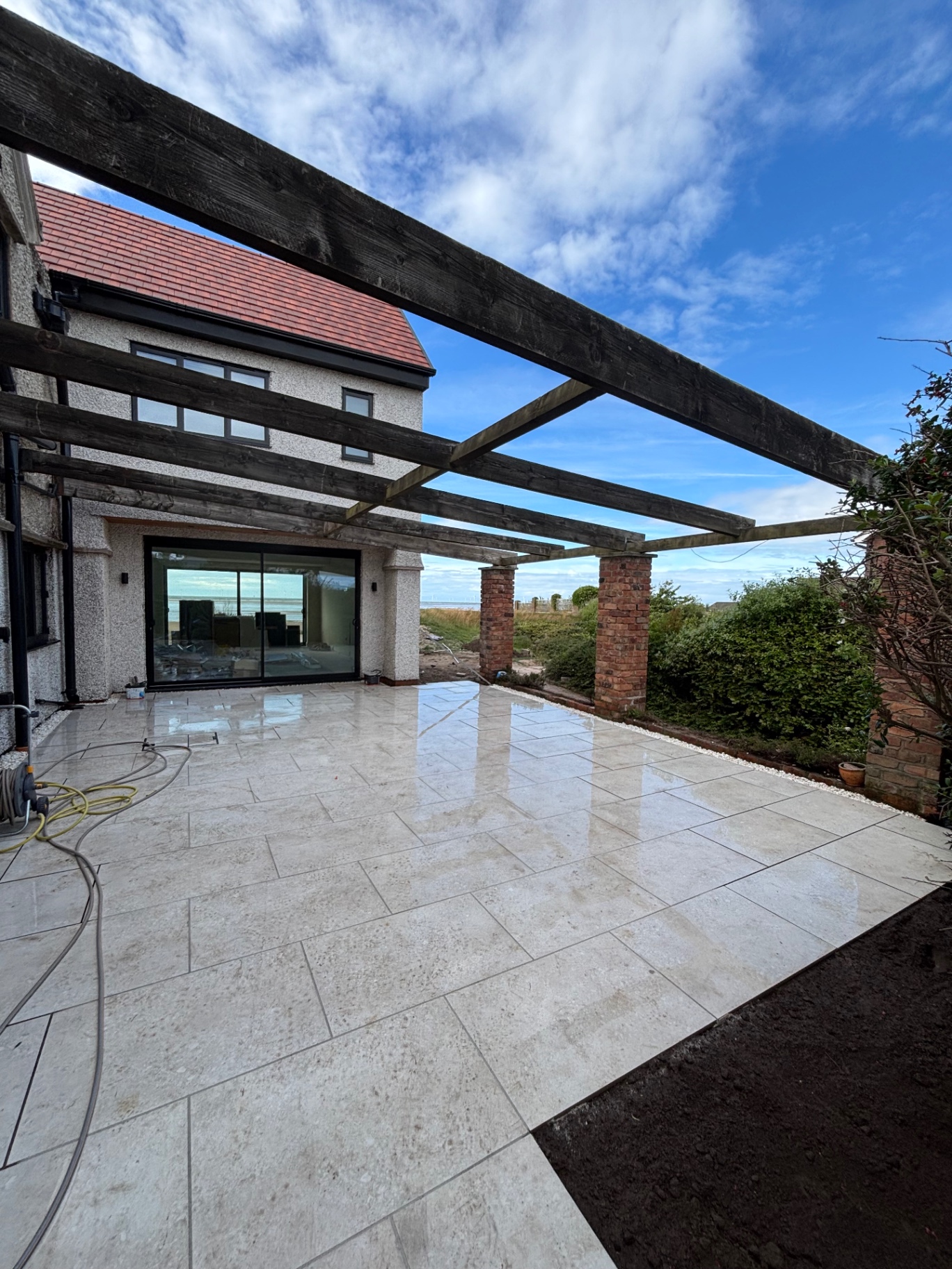 Cream porcelain patio under pergola with sea view