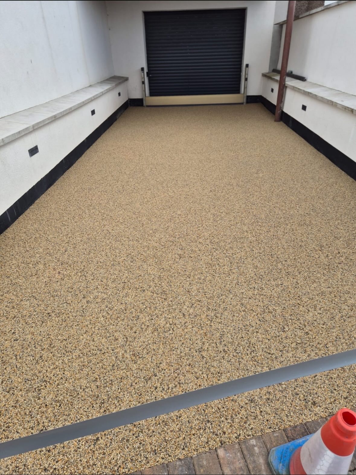 Golden resin bound surface between garage walls