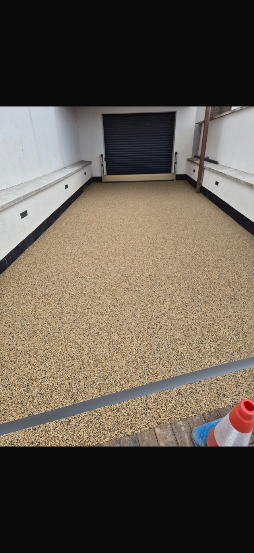 Smooth golden resin driveway leading to garage